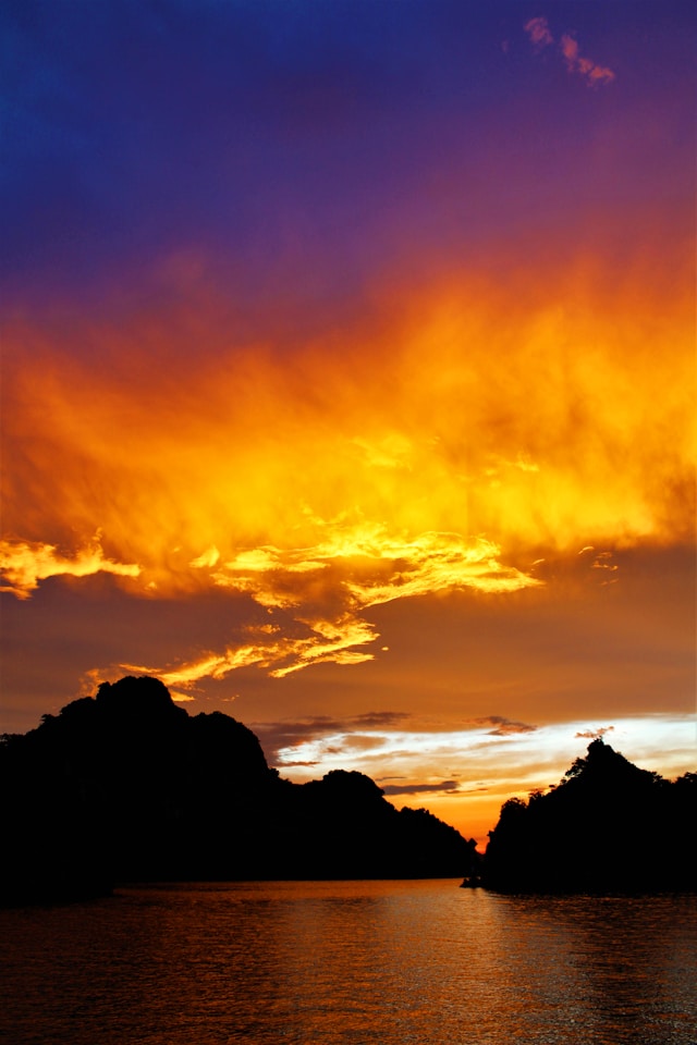 Scenic view of mountains and sunset over Halong Bay with vibrant sky colors